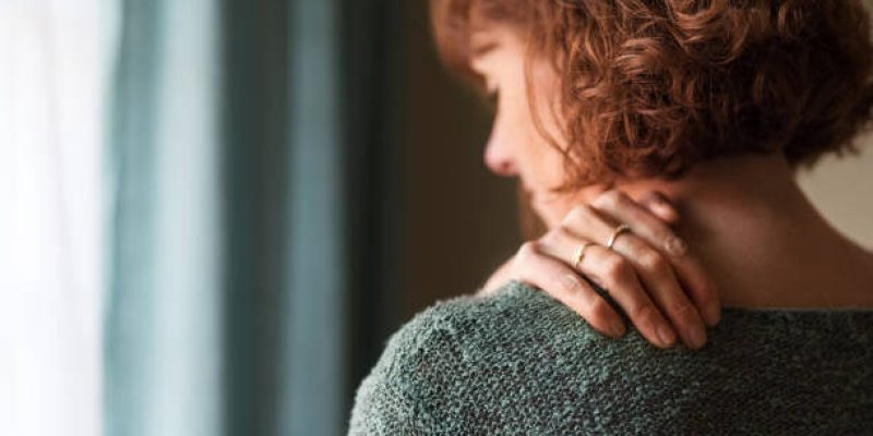 Rear view shot of a woman suffering from a shoulder pain