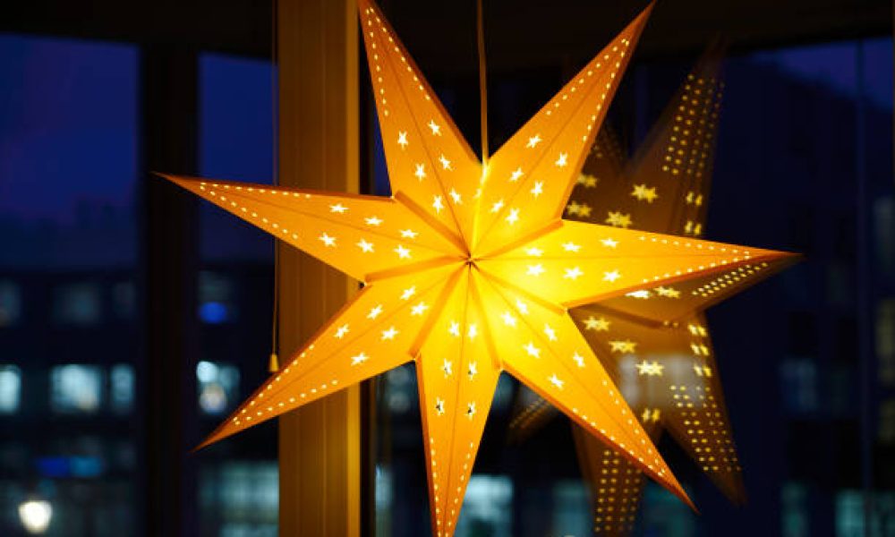 Decorative Christmas star on a window on a winter evening during the Christmas holidays